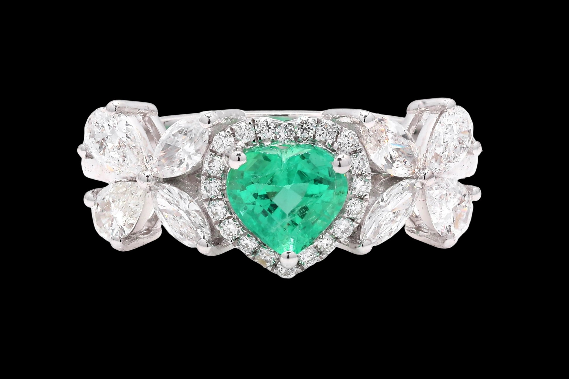 Ring with a heart-shaped emerald and diamond accents on a white background