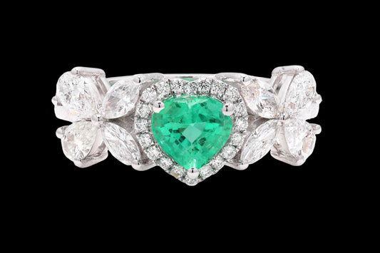 Ring with a heart-shaped emerald and diamond accents on a white background